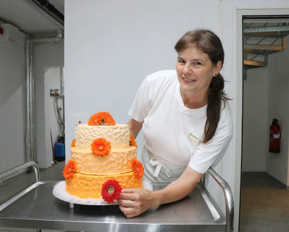Sybille Rüdiger dekoriert eine Hochzeitstorte mit echten Blüten. Die Konditorin aus Lengefeld arbeitet seit der Eröffnung im Rosen-Café des Rosariums in Sangerhausen.