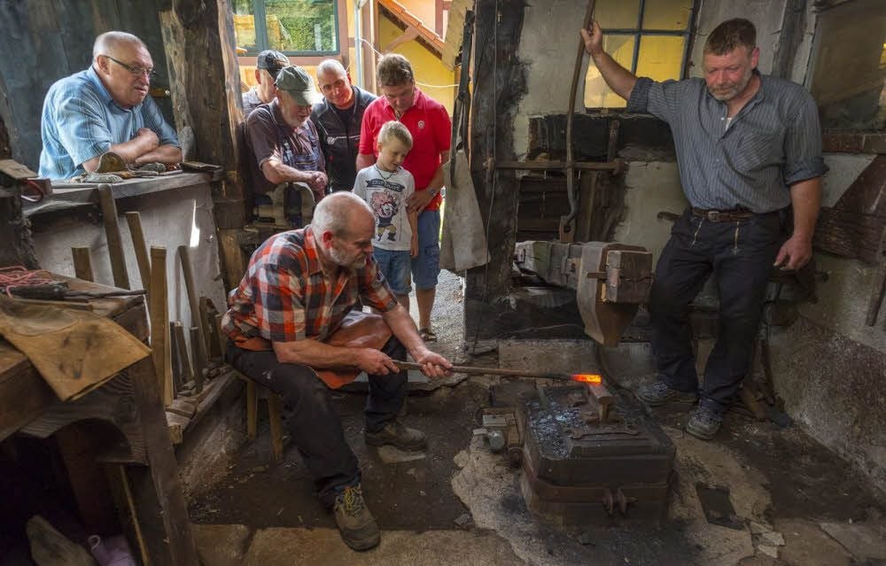 Michael Zwingelberg (r.) und Frank Ritter zeigen Besuchern, wie sie mit Hilfe ihres 50-Kilogramm-Fallhammers Damaststahl herstellen.