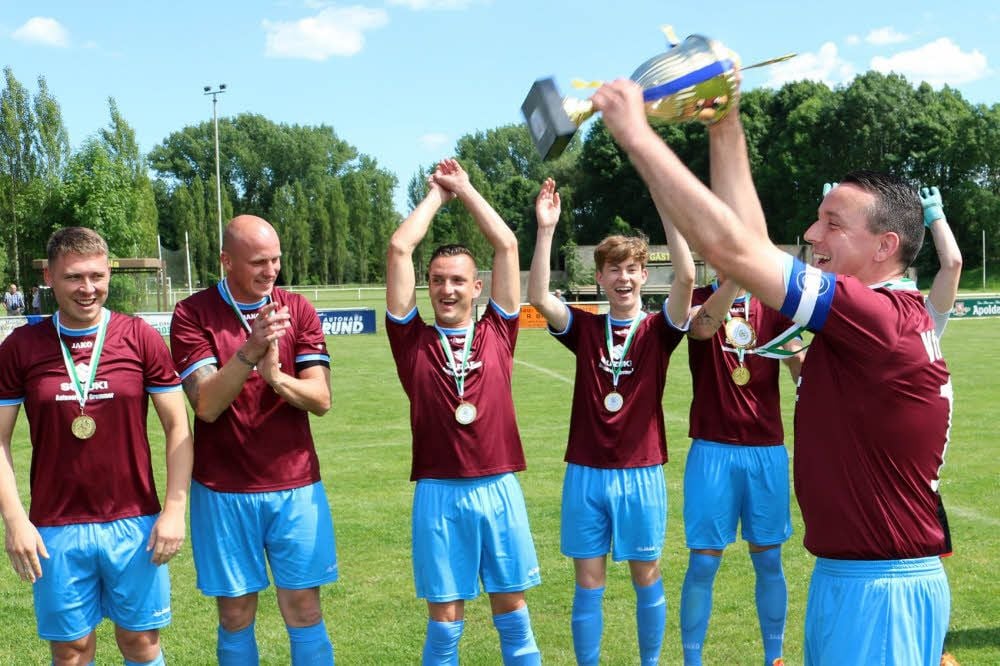 Mannschaftskapitän Uwe Brandt und die Roßlaer Kicker bejubeln den Meisterpokal.