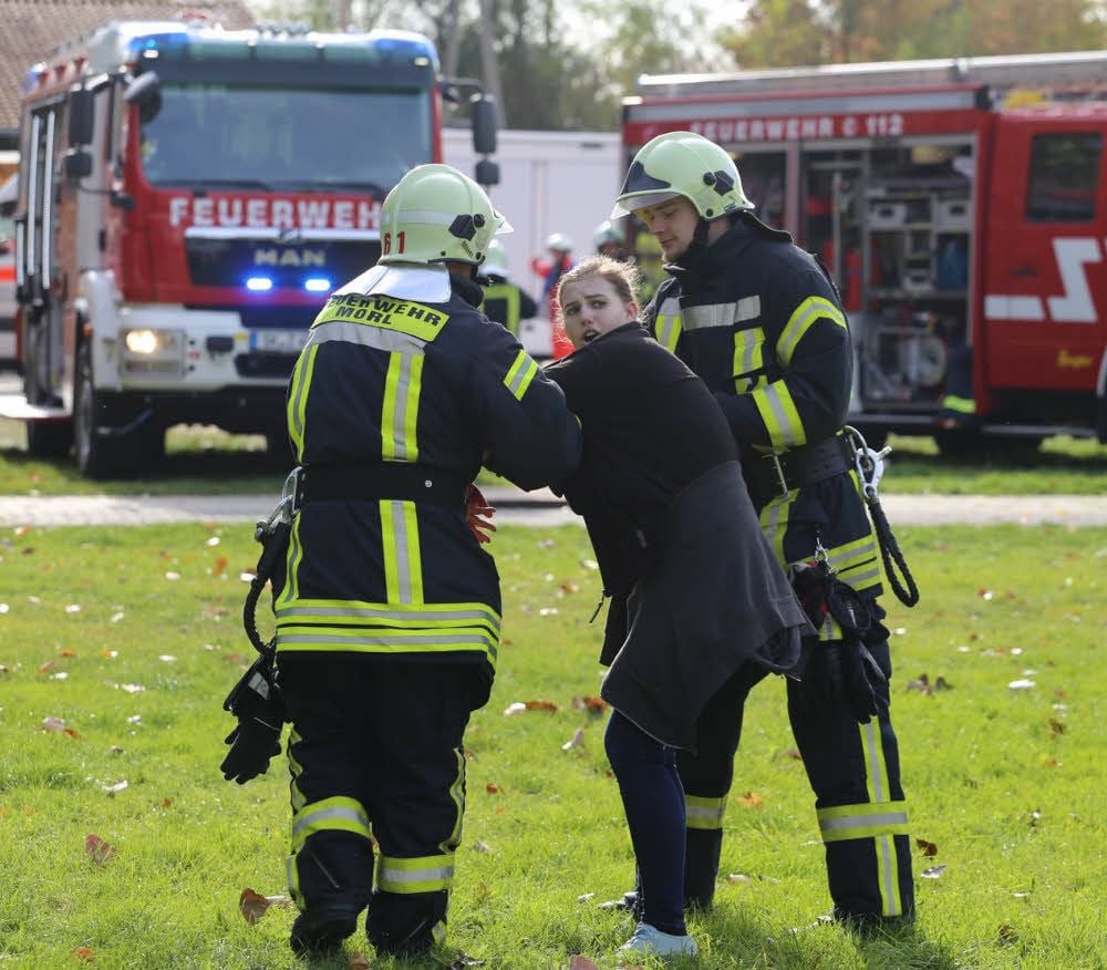 Feuerwehr-Kräfte kümmern sich um eine „Verletzte“ und beruhigen sie.
