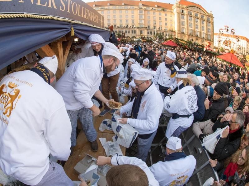 Stollenbäcker verkauften nach der Eröffnung des 23. Stollenfest auf dem Striezelmarkt in Dresden den 3,55 Meter langen, 1,73 Meter breiten, 88 Zentimeter hohen und 2.872 Kilogramm schweren Riesenstollen. Foto: Arno Burgi/dpa-Zentralbild
