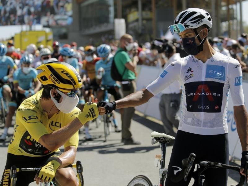 Hat das Gelbe Trikot verteidigt: Primoz Roglic (l) begrüßt Egan Bernal am Start mit einem Faustschlag. Foto: Christophe Ena/AP/dpa