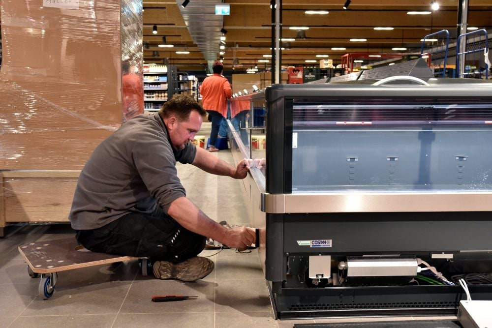 Thomas Tesch von der Firma Thelen Werbetechnik Halle beklebt eine der neuen Kühltheken in dem Edeka-Markt.