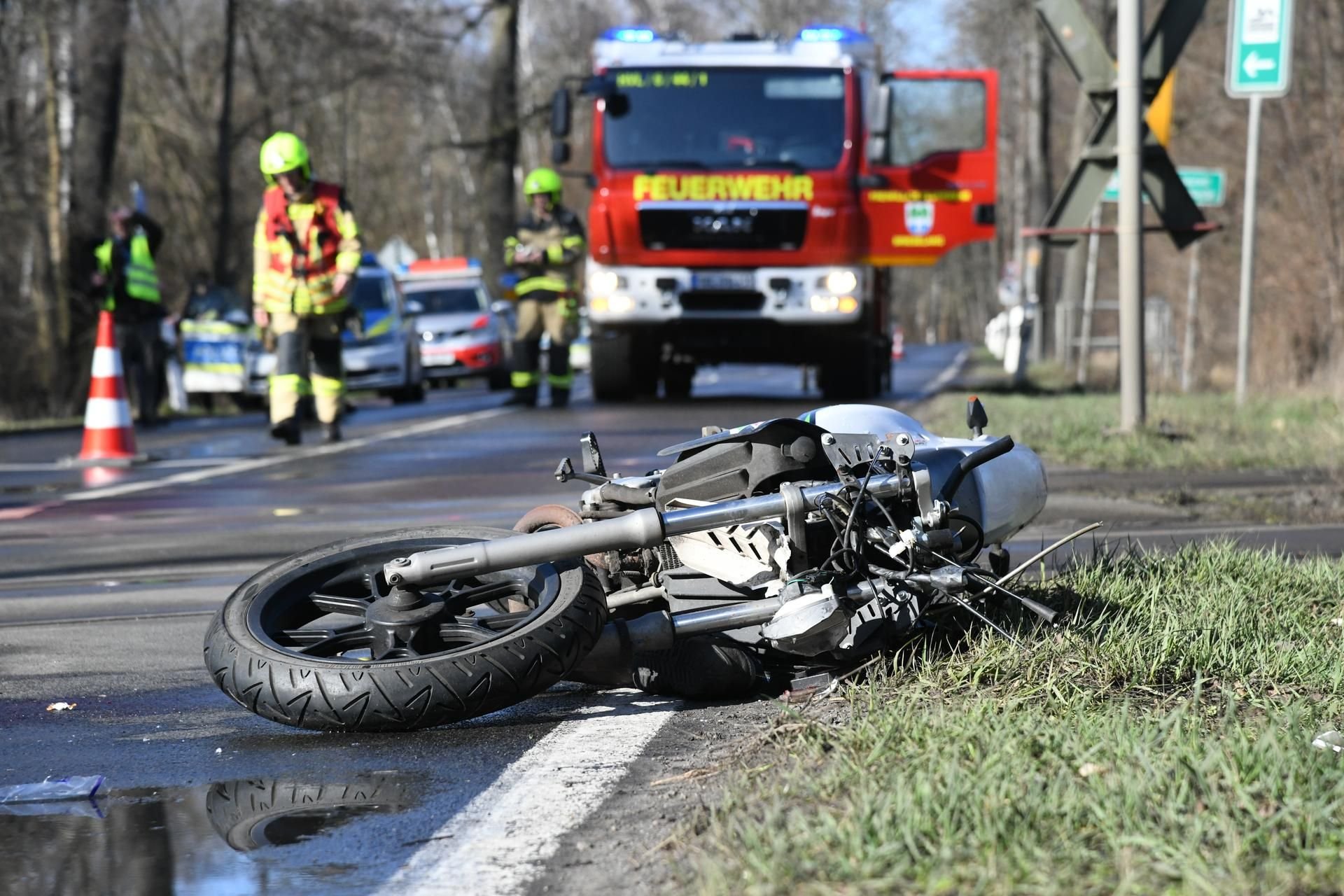 Ein Motorrad liegt an einem Bahnübergang bei Brieselang (Brandenburg) neben der Straße.
