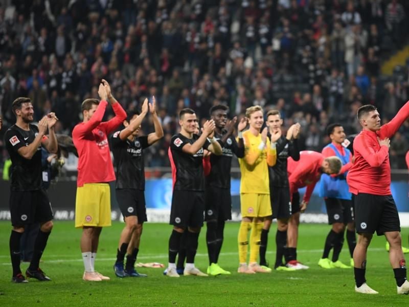 Die Frankfurter Spieler mit dem fünffachen Torschützen Luka Jovic (2.v.r.) feiern nach dem 7:1-Sieg vor dem Fanblock. Foto: Arne Dedert/Archiv