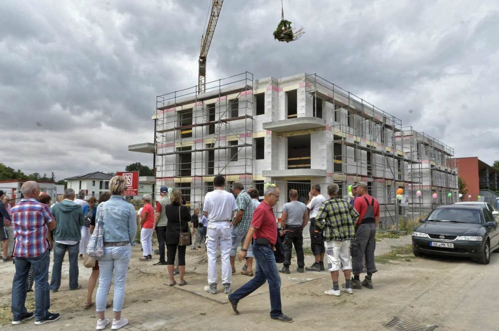 Der Richtkranz schwebt über dem Rohbau im Ziebigker Wohngebiet an der Elbe.