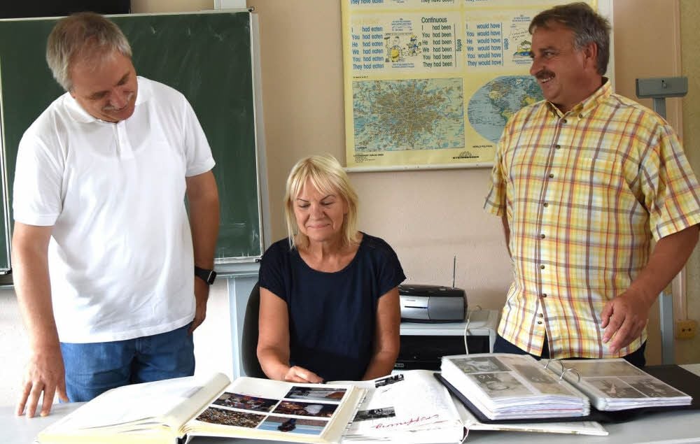 Christina Helms zeigt Volker Henneberg (li.) und Uwe Höhne Bilder in der Chronik.