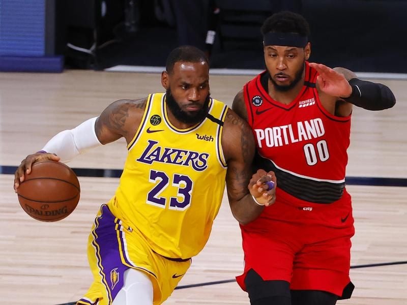 Lakers-Superstar LeBron James (l) im Duell mit Carmelo Anthony von den Portland Trail Blazers. Foto: Kevin C. Cox/Pool Getty Images/AP/dpa