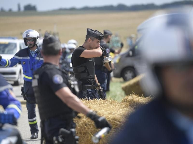 Französische Polizisten greifen während der 16. Tour-Etappe zu Pfefferspray. Foto: Yorick Jansens/BELGA