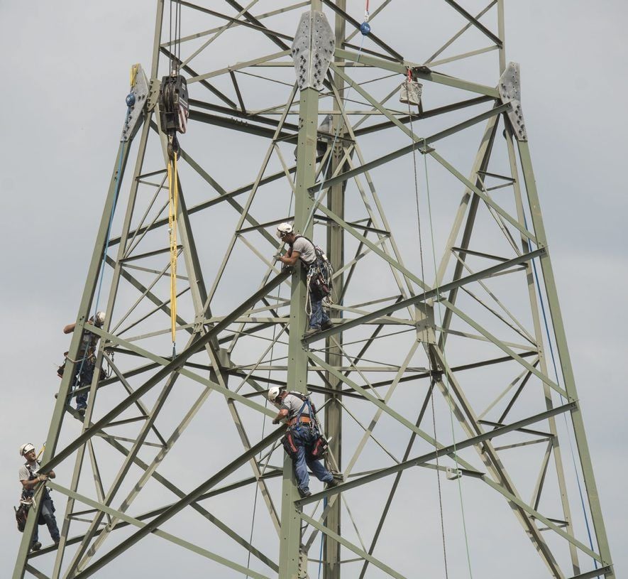 Die neuen Strommasten sind bis zu 60 Meter hoch. Die Arbeiter, die ähnlich wie in einem Kletterpark gesichert sind, stehen oft lange Zeit dort oben, nur auf den schmalen Diagonalen.