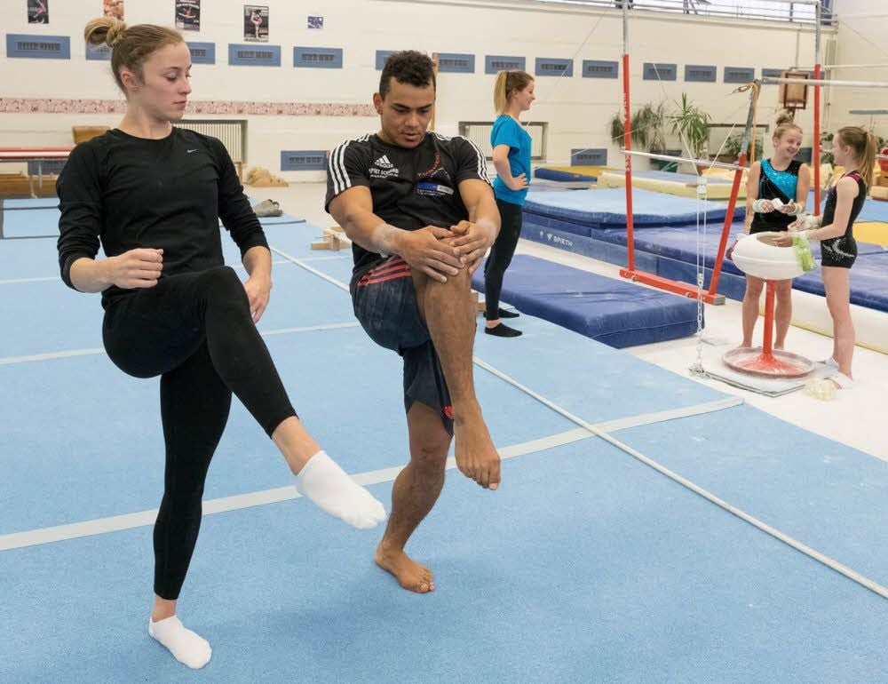 Matthias Fahrig übt mit Nadja Schulze am Boden. Im Hintergrund spricht Conny Schütz mit zwei Talenten.