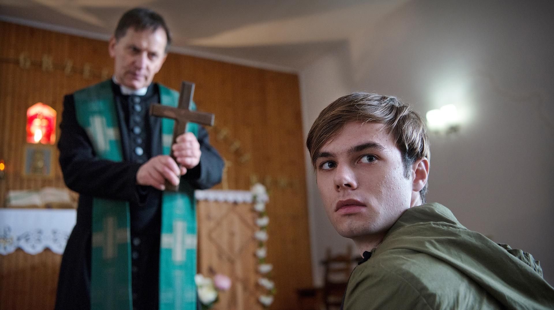 Jonas Fleischauer (Tom Gronau, r) muss sich regelmäßig von Pater Anselm (Maciej Robakiewicz, l) exorzieren lassen.