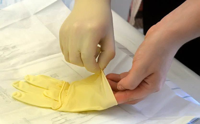 Auch das Anziehen der Schutzhandschuhe erfordert Übung.