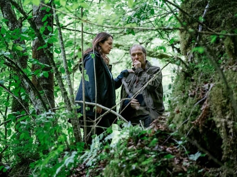 Jana Winter (Natalia Wörner) versucht ihrem Kollegen Brauner (Martin Brambach) beizustehen, der auf einem Waldweg angeschossen wurde. Foto: ZDF/Marco Nagel