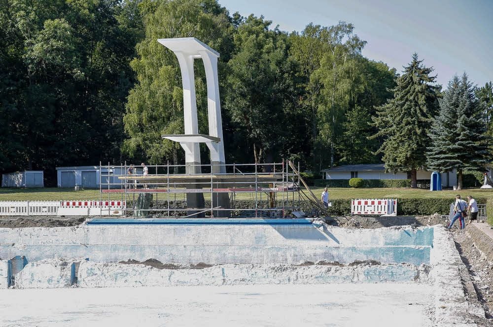 Blick in das alte Schwimmerbecken des Freibades, das jetzt zum Teil abgetragen wurde. Am Rand steht der Zehn-Meter-Sprungturm.