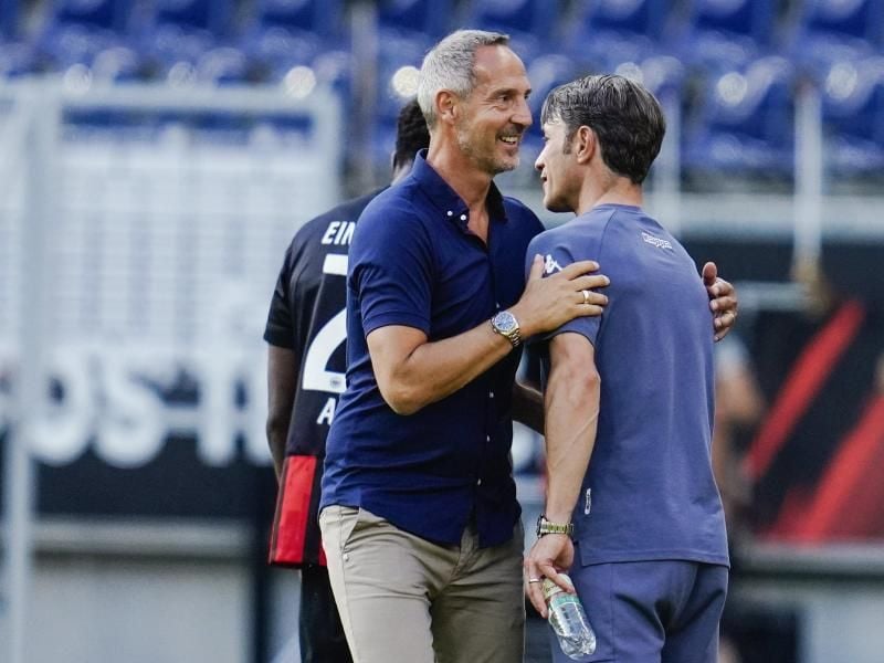 Frankfurts Trainer Adi Hütter (l) verabschiedet sich von Monacos Trainer Niko Kovac. Foto: Uwe Anspach/dpa/Archivbild