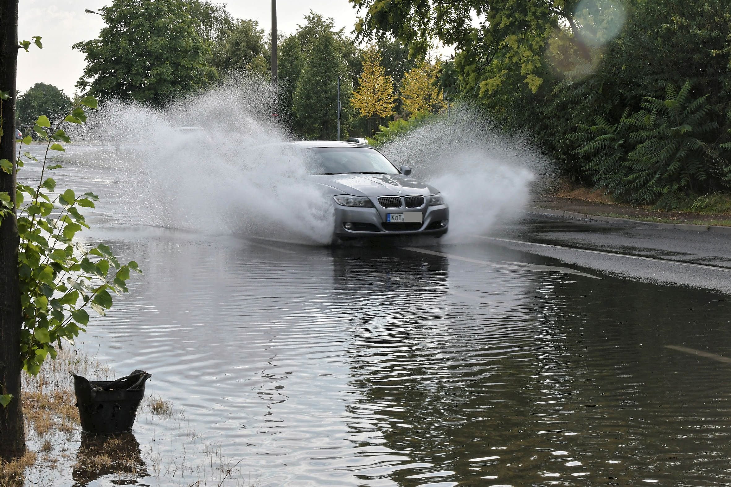Autos fahren durch die regenüberflutete Weststraße.