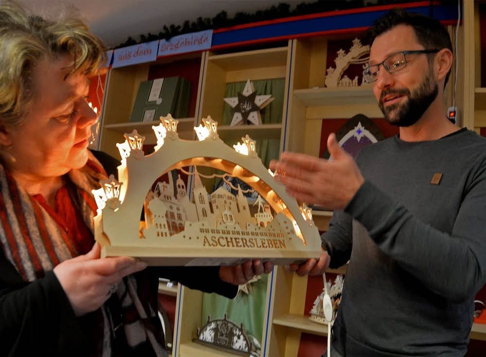 Astrid Schmith und Grafik-Designer Silvio Merkwitz zeigen den Aschersleben-Schwibbogen, der im Buchhaus am Markt besonders gefragt ist.