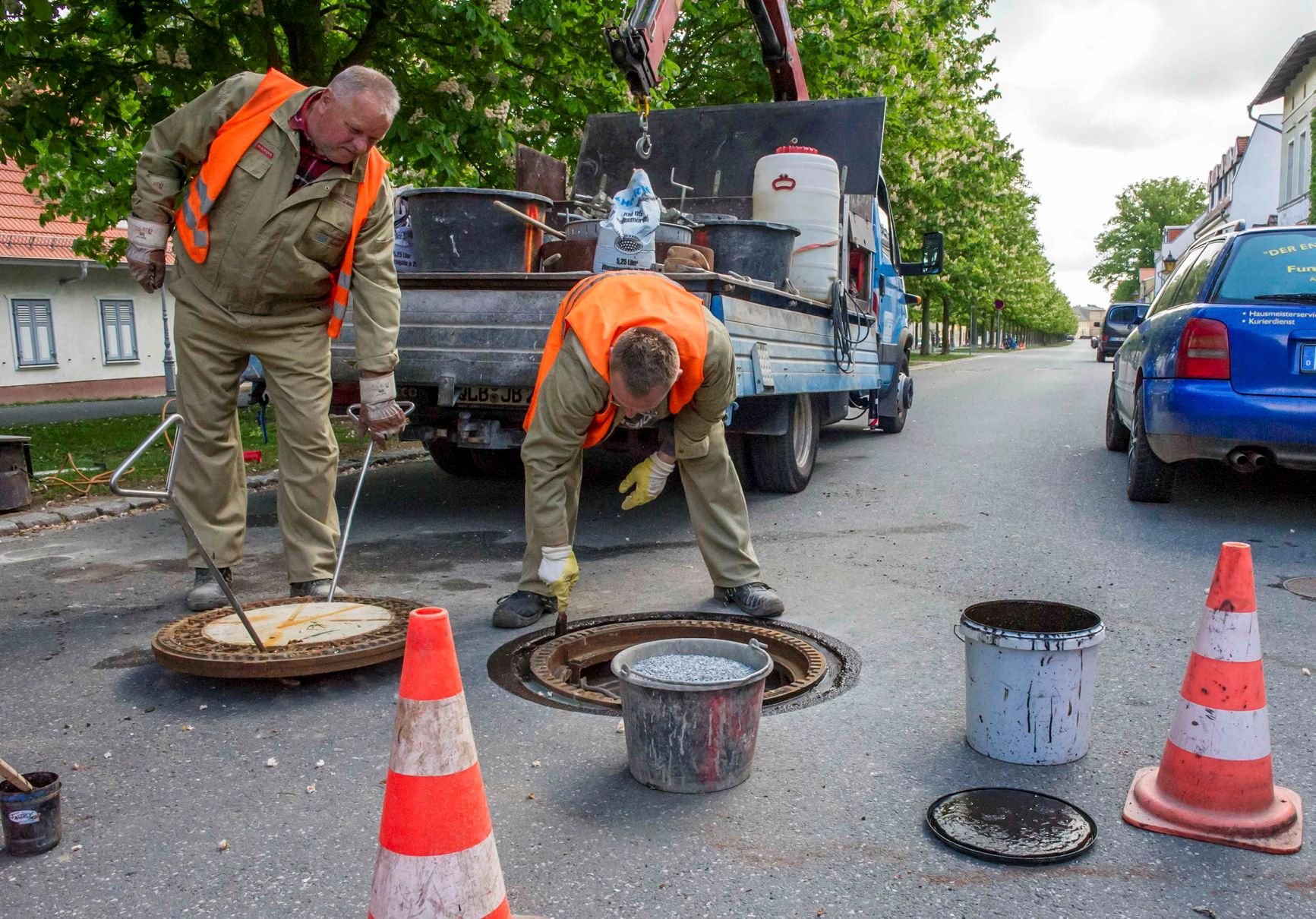 Mitarbeiter des Zweckverbandes reparieren Schachtabdeckungen in Ballenstedt.