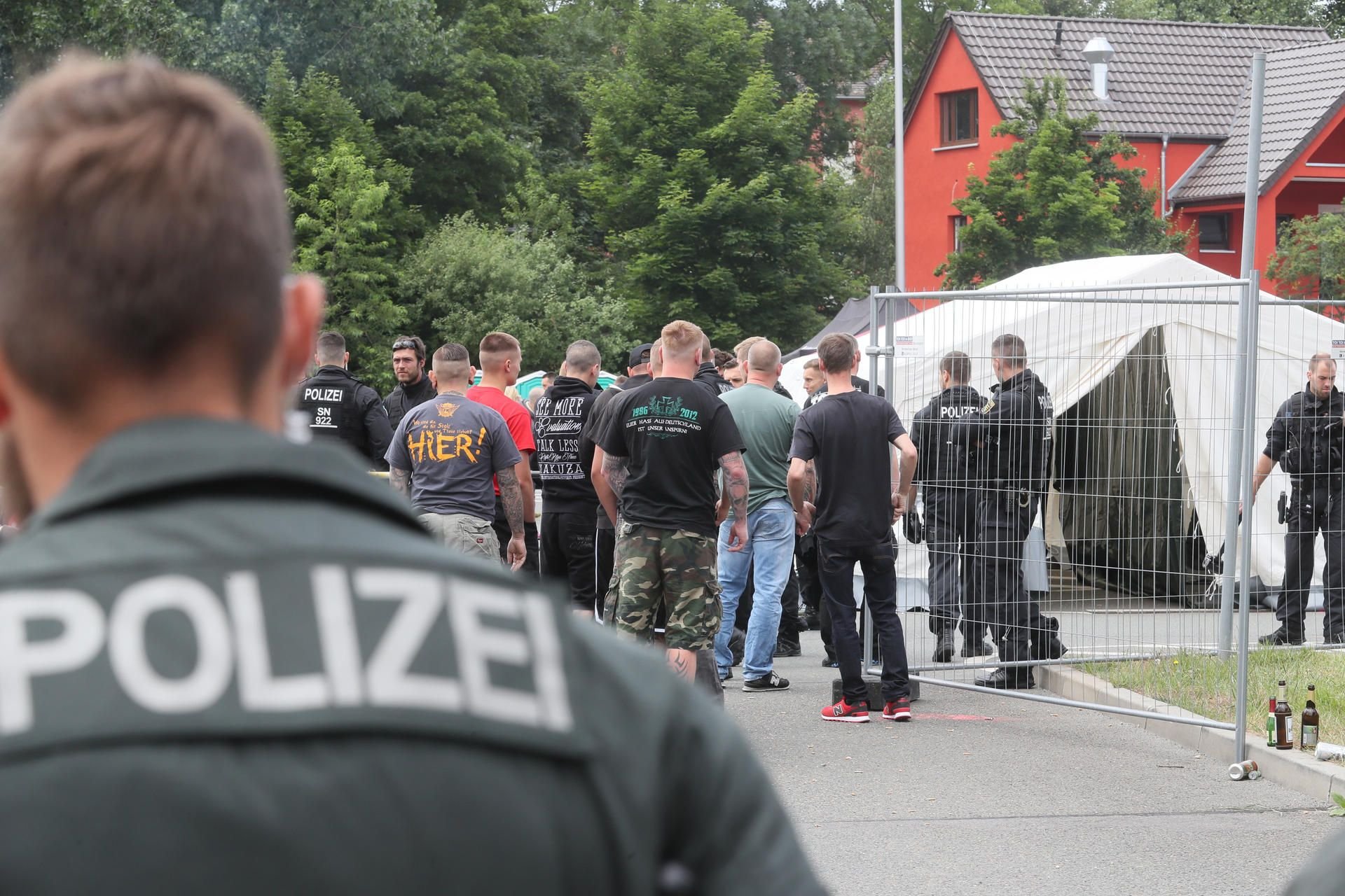 Polizeibeamte und Teilnehmer des RechtsRock-Festivals «Rock für Deutschland» stehen auf dem Veranstaltungsplatz in Gera.