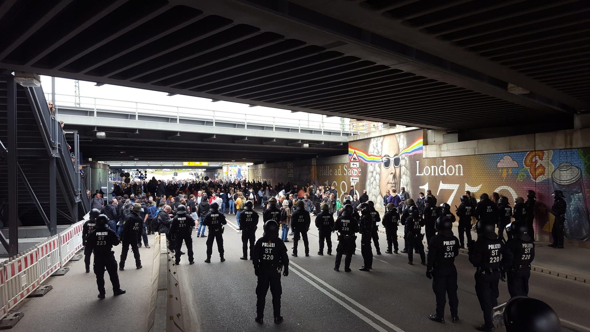 Auf der Delitzscher Straße unter der Eisenbahnbrücke stehen linke Demonstranten der Polizei gegenüber.