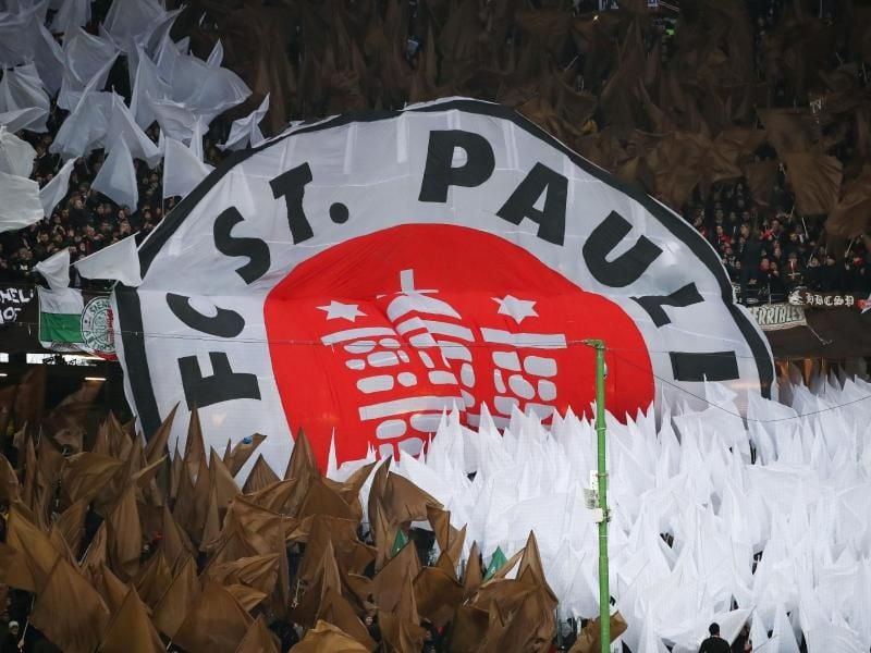 FC St. Paulis Fans zeigen auf der Bühne ein Banner mit dem Vereinslogo. Foto: Christian Charisius/dpa/Archivbild