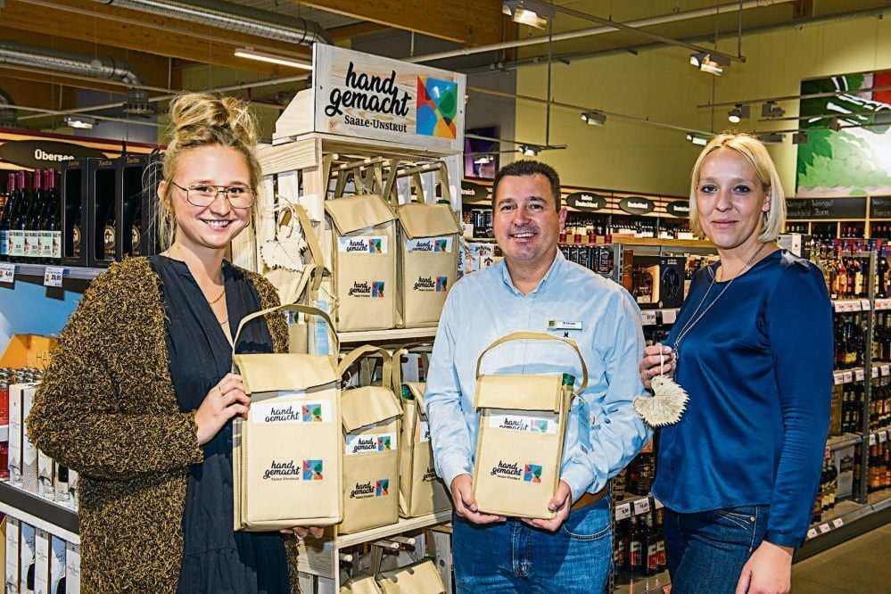Katharina Albrecht (l.), Daniel Hinze (E-Center) und Peggy Wagenbrenner (Integra Weißenfels) präsentieren die Tasche.