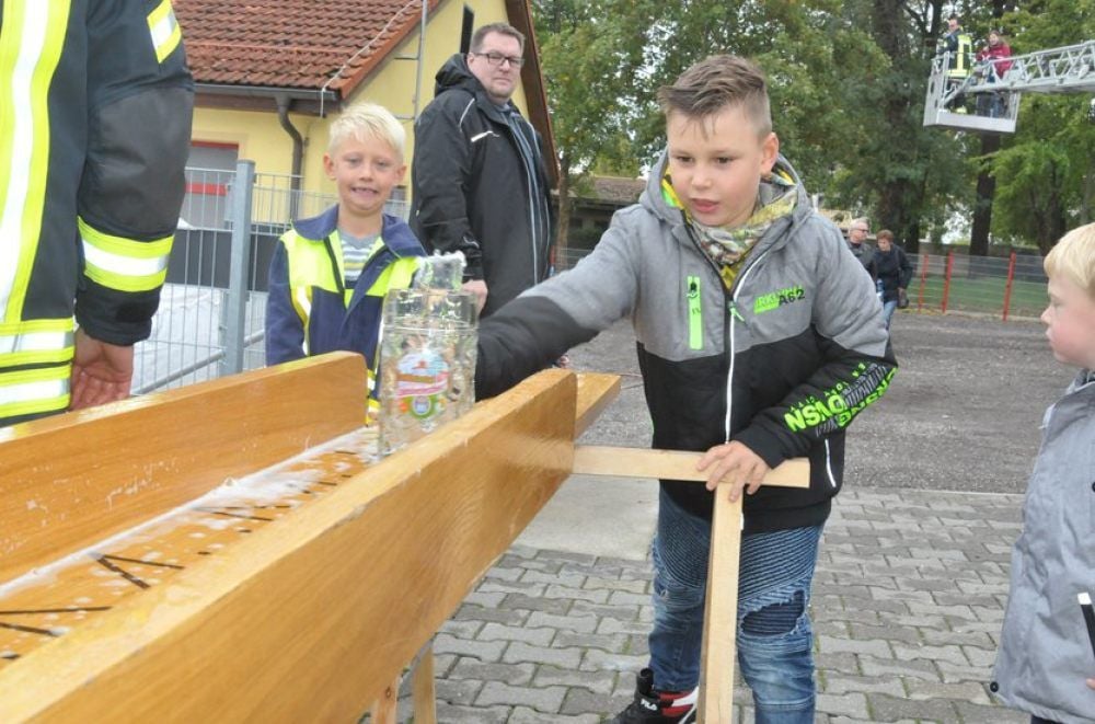 Der neunjährige Jonas hat den Schwung raus: Beim Bierkrugschieben befördert er das mit Wasser gefüllte Gefäß ins Bassin am Ende der Rutschbahn.