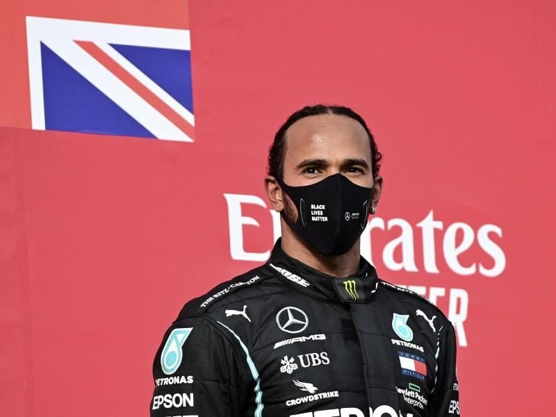 Lewis Hamilton vom Team Mercedes steht nach seinem Sieg in Imola auf dem Podium. Foto: Miguel Medina/AFP Pool/AP/dpa
