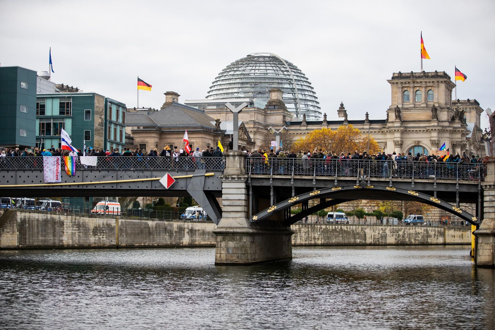 Teilnehmer einer Demonstration gegen die Corona-Einschränkungen der Bundesregierung stehen nahe dem Reichstagsgebäude auf der Marschallbrücke.