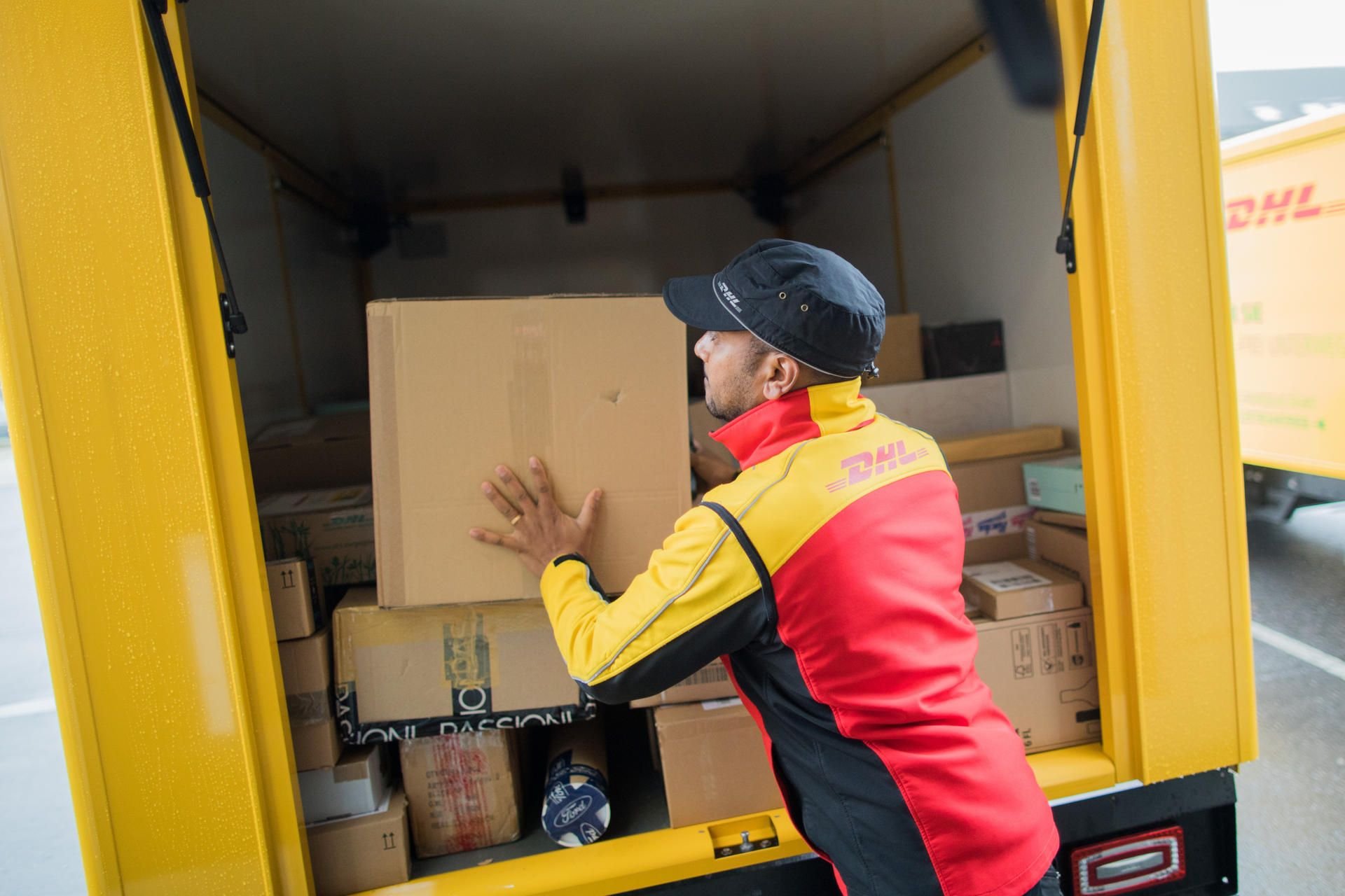 Ein Paketbote lädt in seinen Lieferwagen ein.