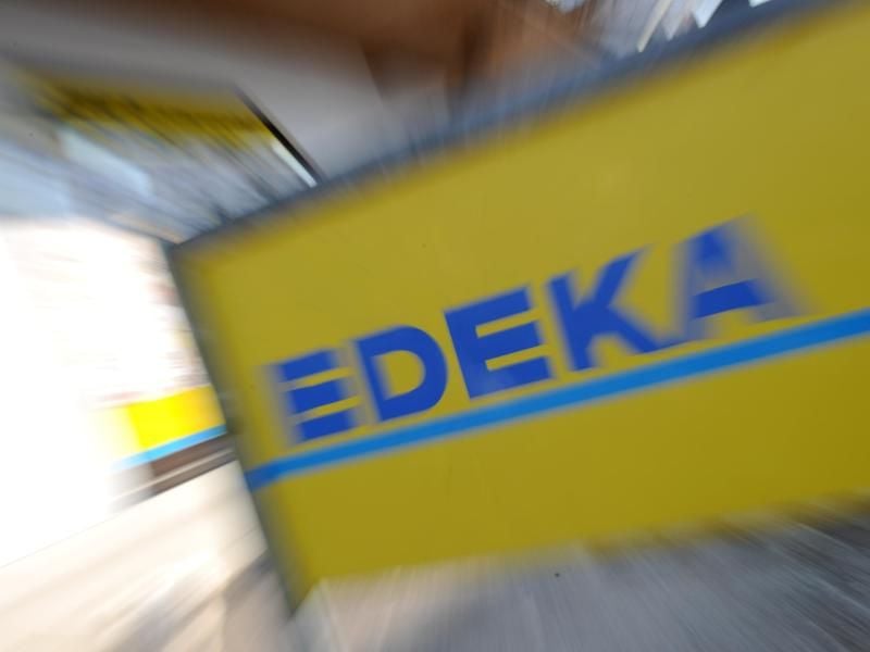 Ein Schild mit der Aufschrift „Edeka” vor einer Supermarktfiliale. Foto: Tobias Hase