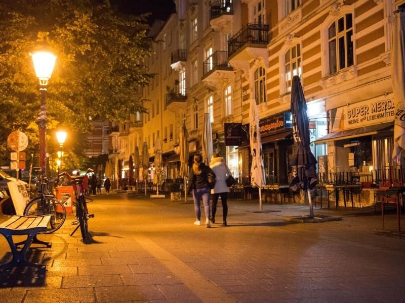 Passanten gehen im Schanzenviertel an geschlossenen Lokalen vorbei. Foto: Daniel Bockwoldt/dpa/Archivbild