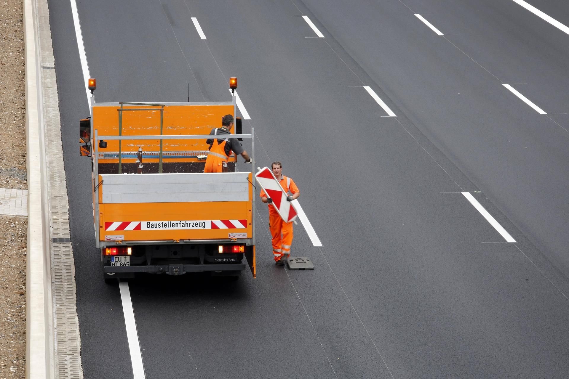 Ein Bauarbeiter auf einer Autobahn.