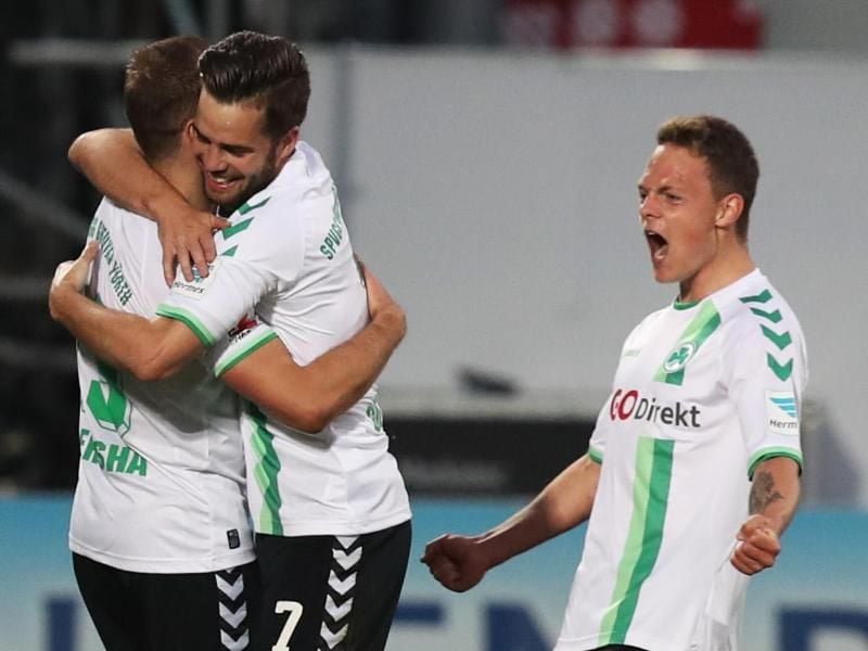 Die Fürther Veton Berisha (l-r), Niko Gießelmann und Patrick Sontheimer jubeln über den Treffer zum 1:0 durch ein Eigentor der Dresdener. Foto: Daniel Karmann