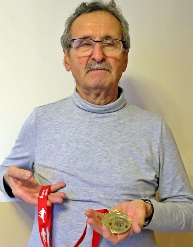 Otto Klempert hält die Erinnerungsplakette, die jeder Teilnehmer am Sonntag anlässlich des Jubiläumslaufes bekommen wird.