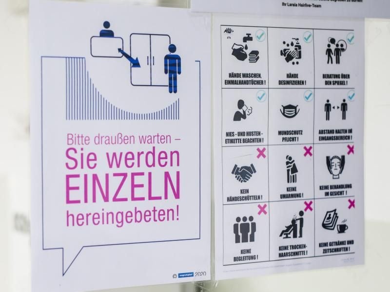 Verhaltensvorgaben weisen Kunden in einem Friseursalon über die neu geltenden Regeln im Salon hin. Foto: Christoph Schmidt/dpa