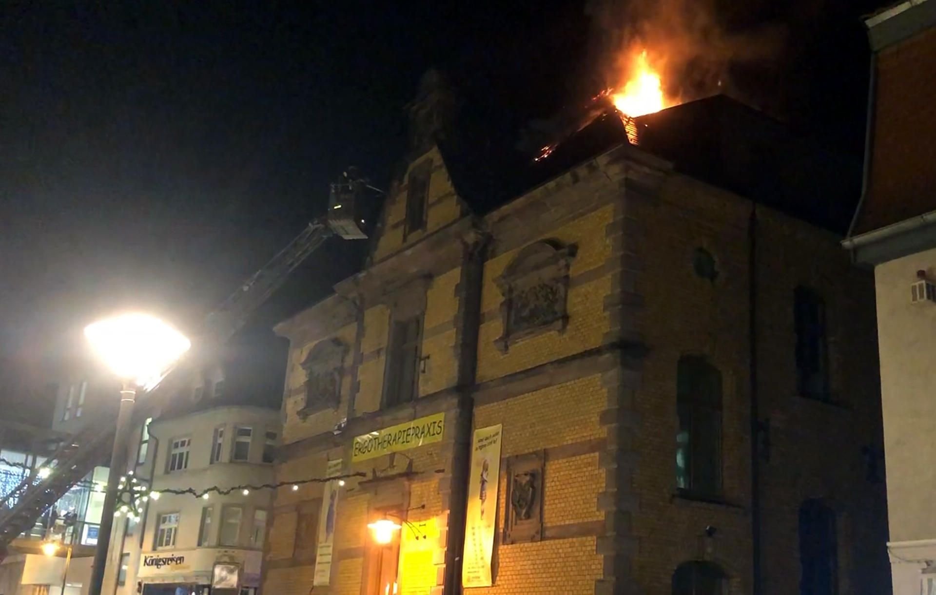 Blick auf einen brennenden Dachstuhl eines ehemaligen Postgebäudes. Bei dem Brand wurde eine Frau verletzt.