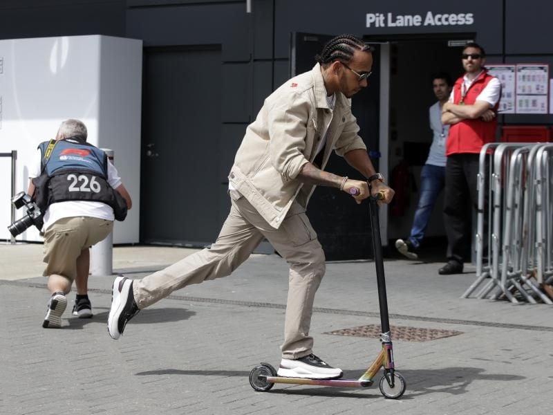 Läuft sich auf der Rennstrecke von Silverstone mit einem Roller warm: WM-Spitzenreiter Lewis Hamilton. Foto: Luca Bruno/AP