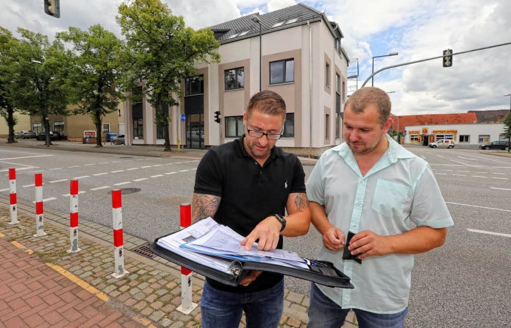 Mario Kövari von der Media GmbH berichtet Wolfens Ortsbürgermeister André Krillwitz (Pro Wolfen) von den Sanierungsarbeiten. Im Hintergrund ist die neue Fassade der ehemaligen Ruine in der Leipziger Straße zu sehen. Erst vor wenigen Tagen sind dort Gerüste und Planen entfernt worden.