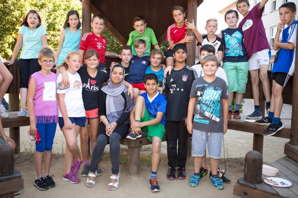 Fatima Ataie (16, vordere Reihe mit Tuch), Farzad Ataie (13) und Sajad Qurbani (12, beide rechts von ihr), lernen an der Sekundarschule.