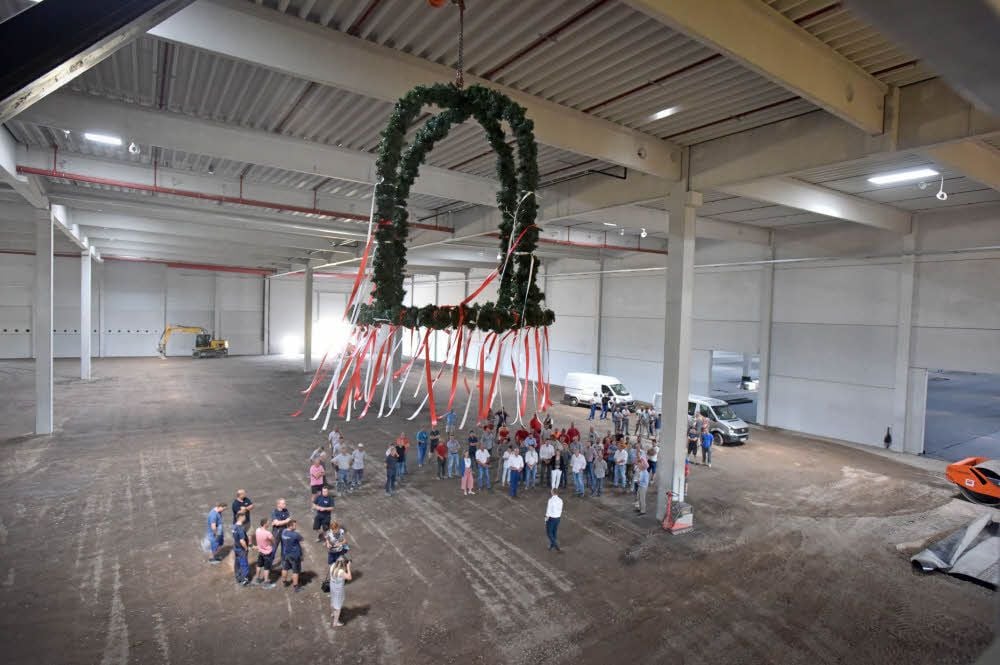 Der Richtkranz schwebt in der Halle. Hier geht im November das Regionallager in Brehna in Betrieb.