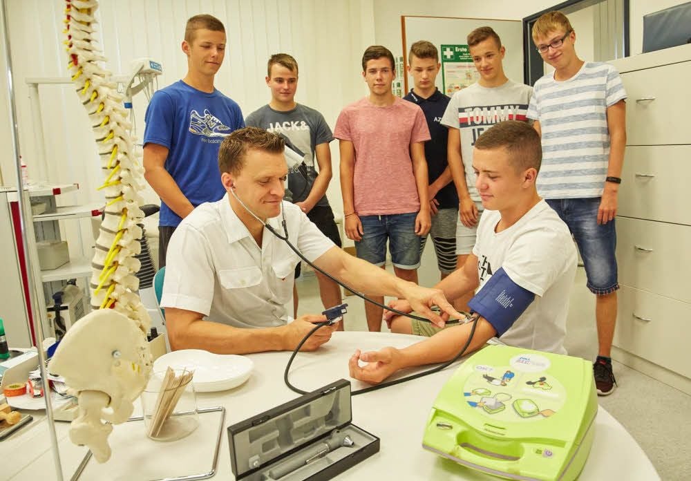Werkssanitäter Jens Hammermann untersucht Tony Herz. Mit ihm zusammen begannen Lieven Rach, Tim Sommer, Johannes Tietz, Mick Eisner, Vincent Rockmann und Nico Egerer eine Ausbildung bei Esco.