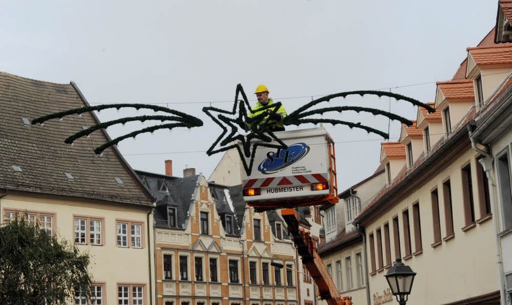 Tobias Lebel von den Eisleber Stadtwerken bringt mit seinen Kollegen rund um den Markt die Adventsbeleuchtung an.