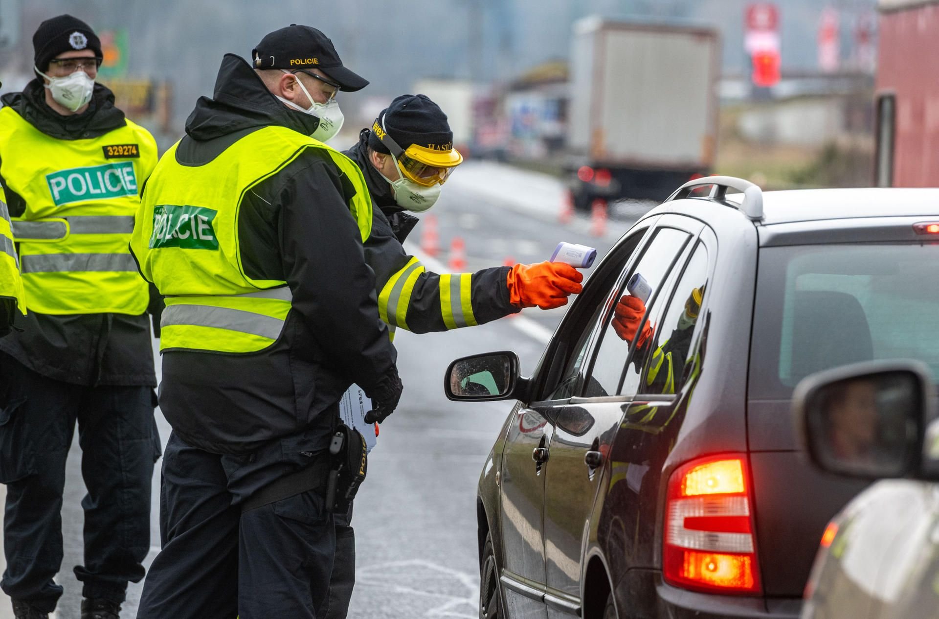 Ceska Kubice: Ein Feuerwehrmann aus Tschechien misst neben Polizisten die Temperatur von einem Einreisenden an der Grenze.