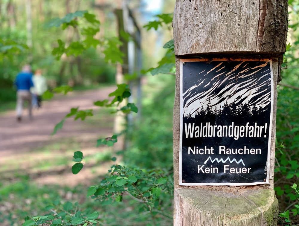Schilder weisen an den Wegen der Dölauer Heide auf die Waldbrandgefahr hin. Die Wege dürfen derzeit nicht verlassen werden.
