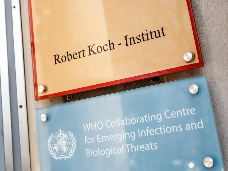Ein Schild mit der Aufschrift "Robert Koch-Institut" weist auf den Eingang des Gebäudes hin. Foto: Carsten Koall/dpa