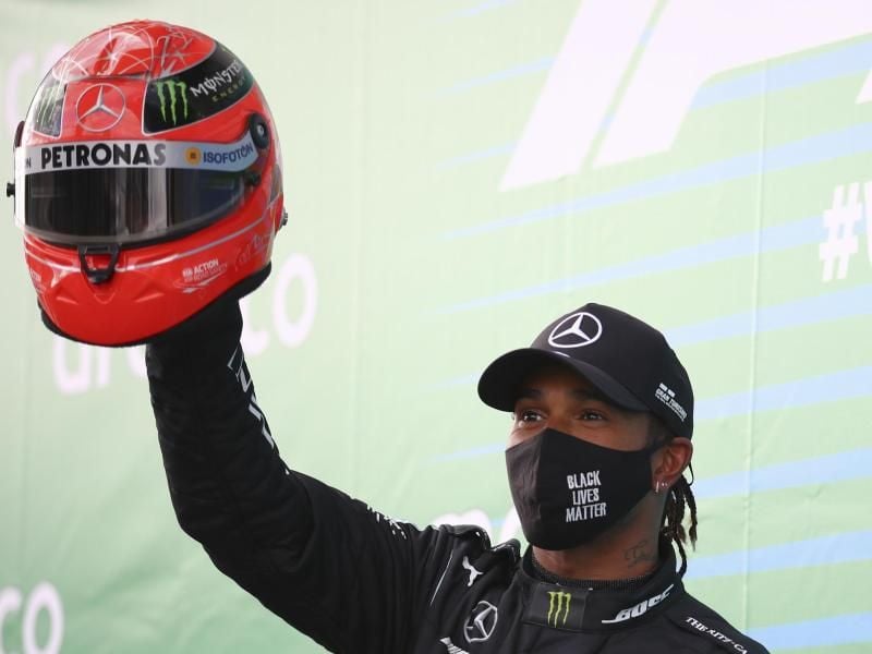 Lewis Hamilton feiert mit dem Helm von Michael Schumacher den Sieg auf dem Nürburgring. Foto: Bryn Lennon/Pool Getty/AP/dpa