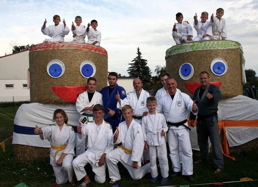 Mit solchen gewichtigen „Kämpfern“ im Rücken wird das Gruppenfoto im Ju-Jutsu-Trainingslagers zum besonderen Spaß.