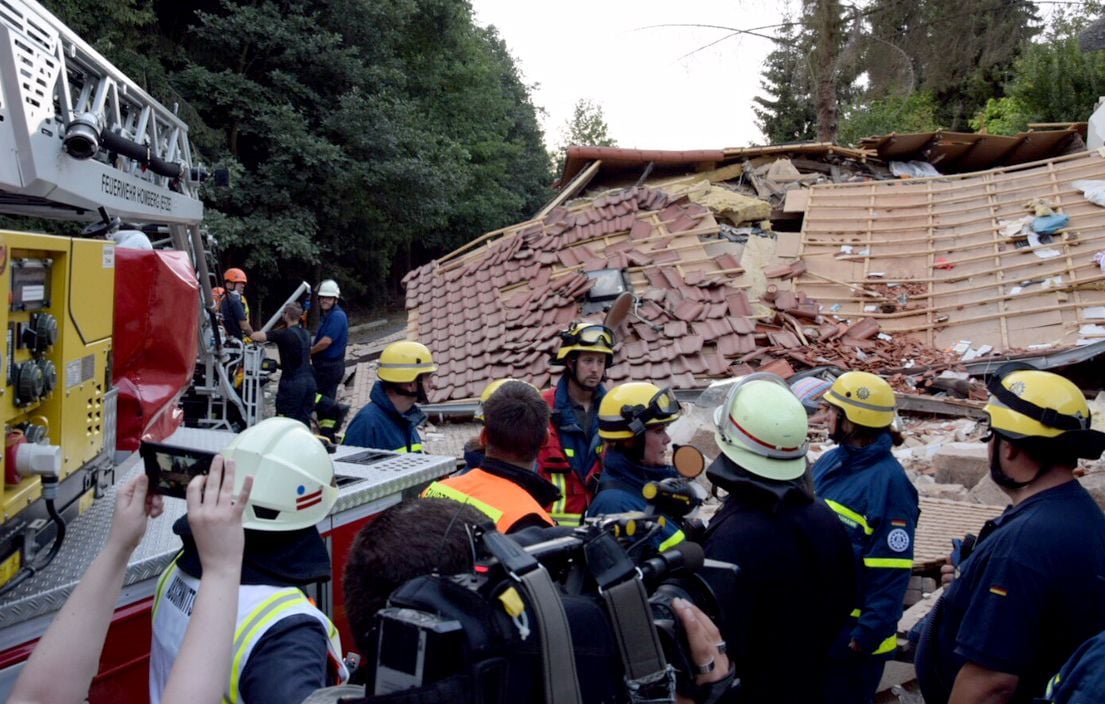Hessen, Knüllwald-Wallenstein: Feuerwehrleute stehen nach einer Gasexplosion vor Trümmerteilen eines eingestürzten Wohnhauses.